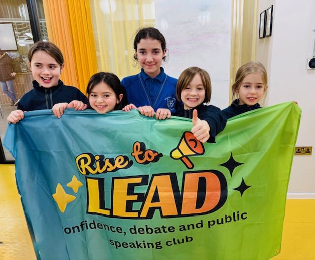Rise to Lead children holding their public speaking club banner