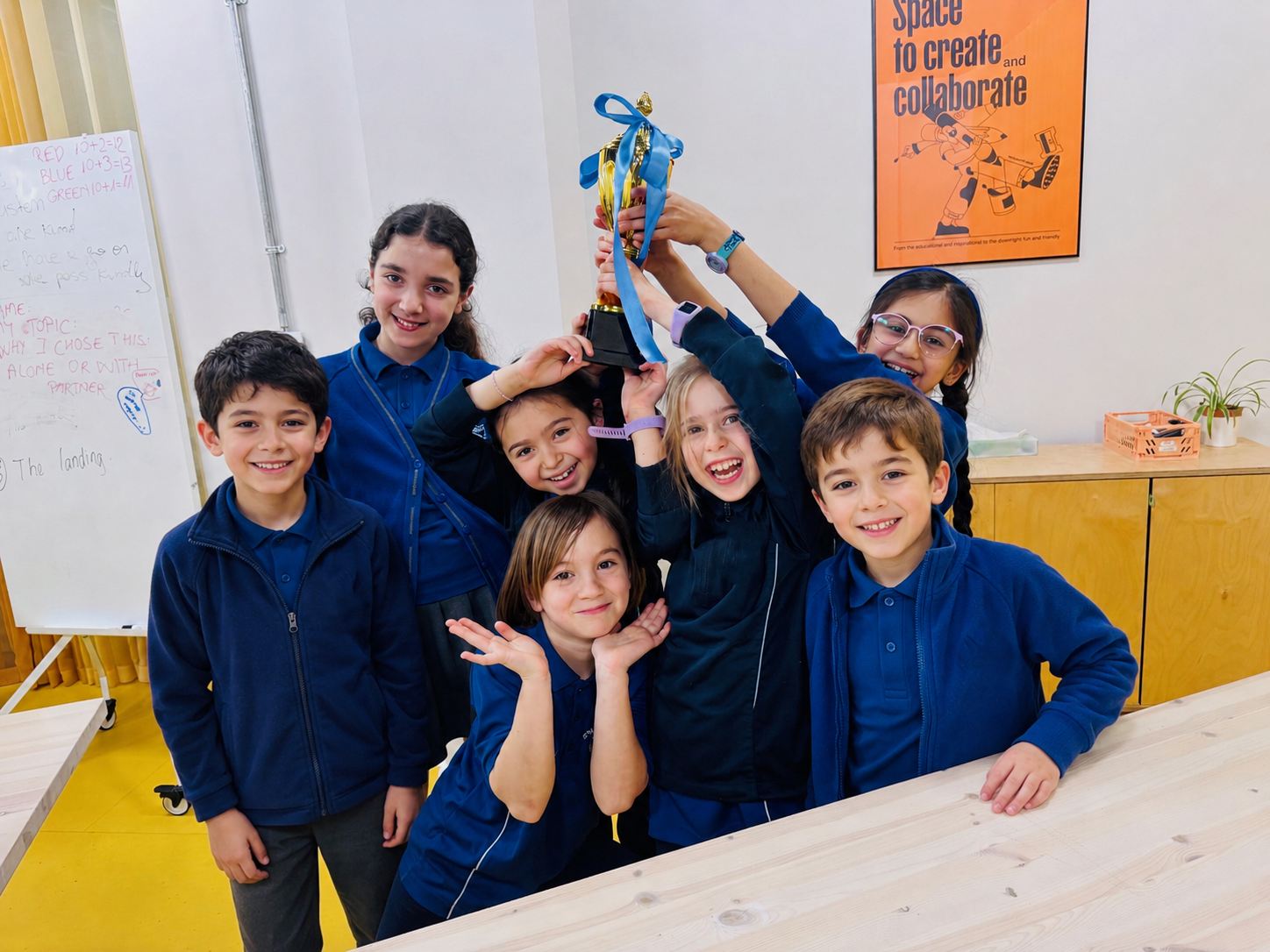 Children celebrating together with a trophy at Configur Academy